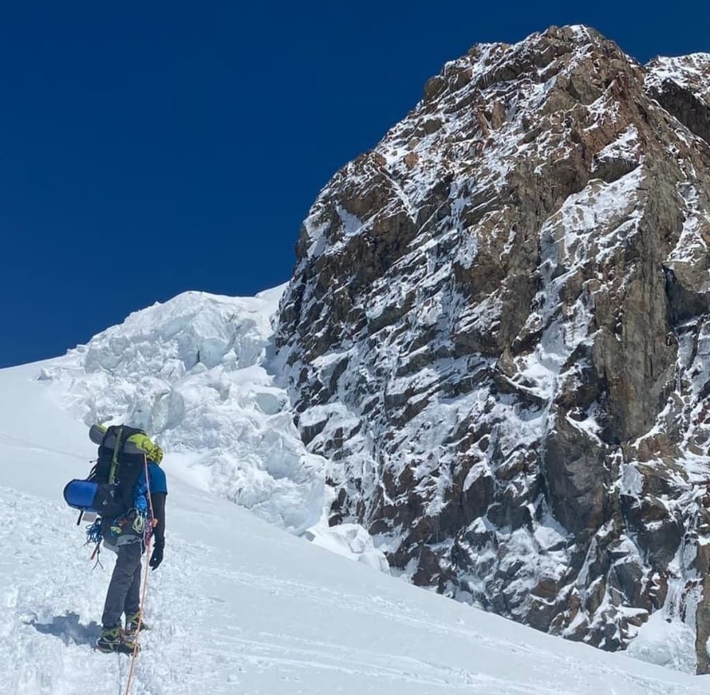 Cresta nevosa con una cordata in salita.